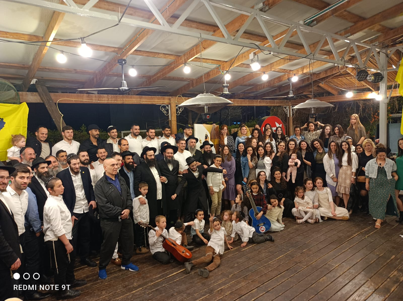 תמונה קבוצתית גדולה של הקהילה בחצר